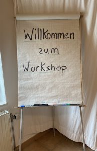 Flipchart-Blatt mit Schrift "Willkommen zum Workshop"